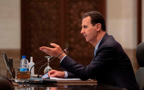 Syrian President Bashar Assad heads a cabinet meeting, in Damascus, Syria, on March 30, 2021. (Syrian Presidency Facebook page via AP)