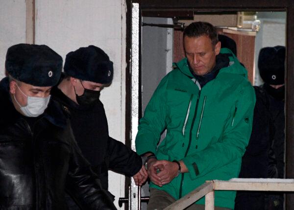 Opposition leader Alexei Navalny is escorted out of a police station on January 18, 2021, in Khimki, outside Moscow, following the court ruling that ordered him jailed for 30 days. (Alexander Nemenov/AFP via Getty Images)