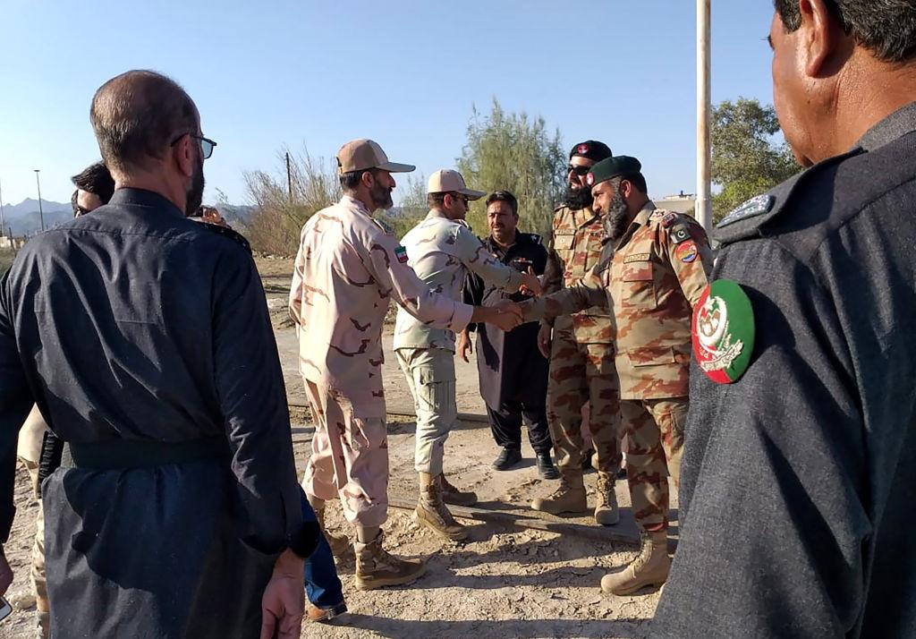 Pakistani border security officials (R) and Iranian border security officials (L) shake hands at Zero Point in the Pakistan-Iran border town of Taftan, Iran, on April 21, 2019. (STR/AFP via Getty Images)