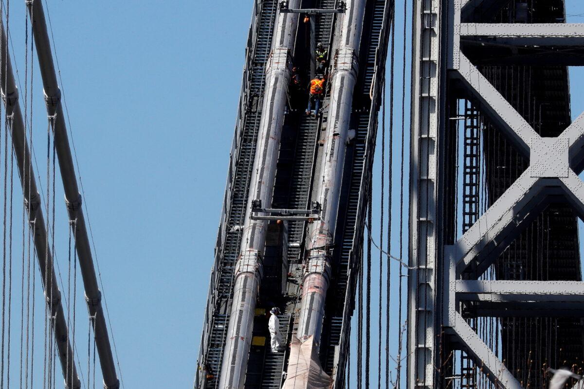 Construction workers on the northeast cables of the George Washington Bridge in New York City on March 30, 2021. (Mike Segar/Reuters)