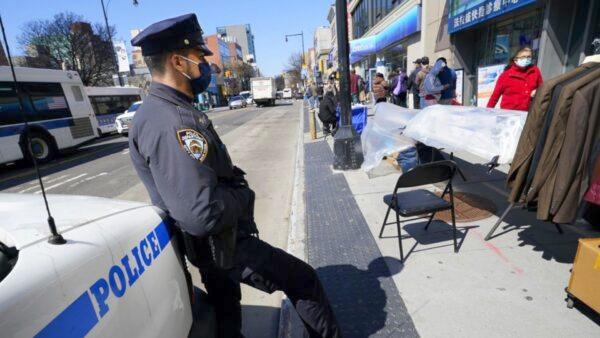 New York Police Department Officer Rodney Hierro keeps an eye on pedestrians walking on Main Street in Flushing, a heavily Asian neighborhood in the Queens borough of New York on March 30, 2021. (Kathy Willens/AP Photo)