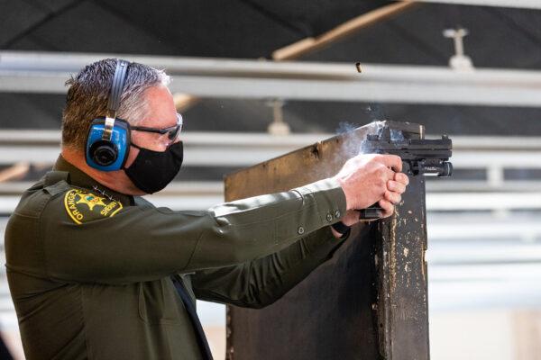 Orange County Sheriff Don Barnes fires his weapon at the Orange County Sheriff Department's shooting Range in Orange, Calif., on March 30, 2021. (John Fredricks/The Epoch Times)