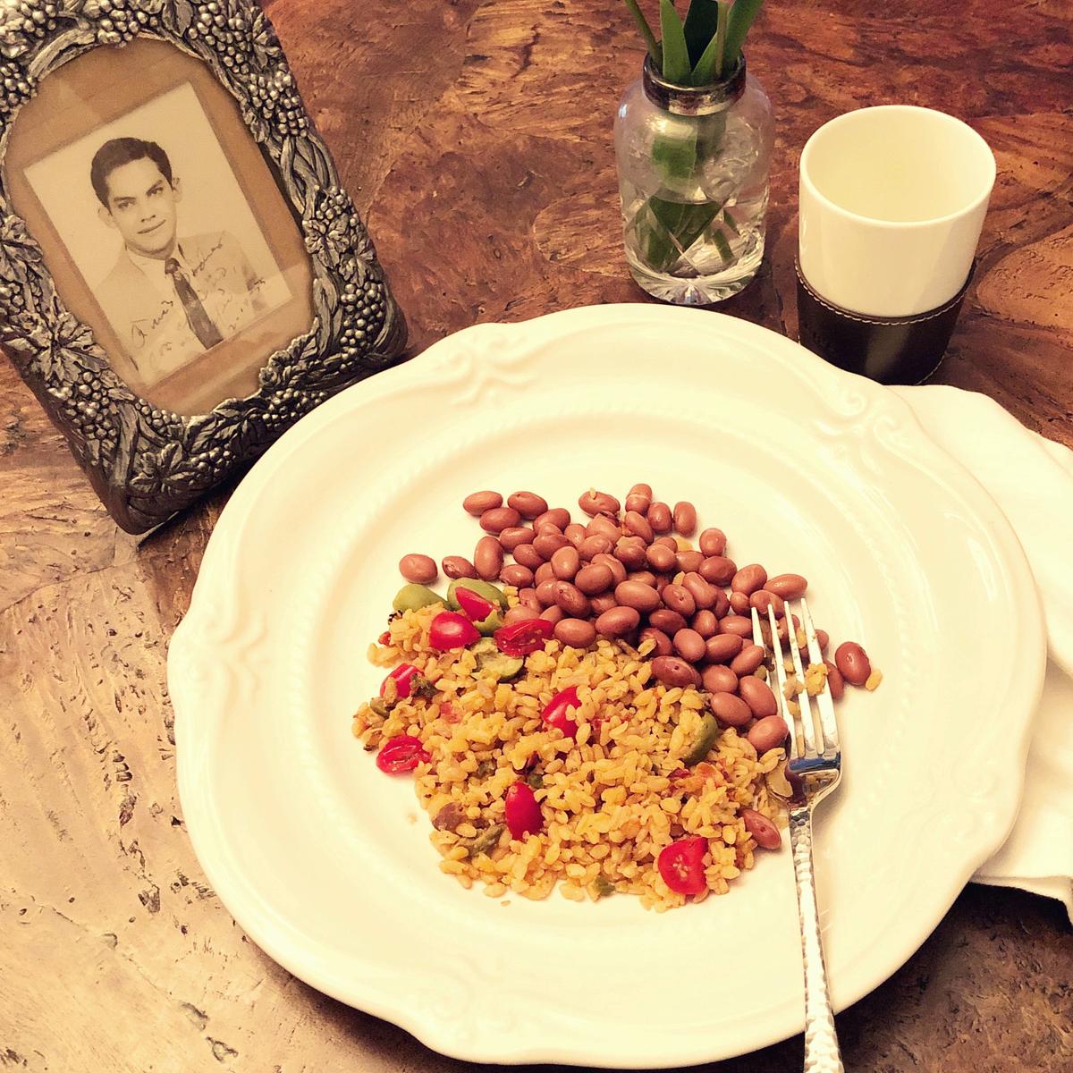 The author's father's rice and beans, along with her favorite photo of her father. It includes a sweet inscription to his parents, sent with letters home in 1955. (Courtesy of Cara Colon-McLauchlan)