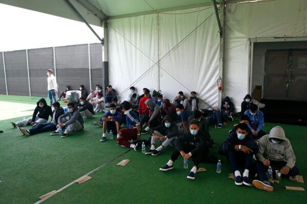 Young minors who tested positive for Covid-19 sit on the ground at the Donna Department of Homeland Security holding facility, the main detention center for unaccompanied children in the Rio Grande Valley run by the US Customs and Border Protection in Donna, Texas, on March 30, 2021. (Dario Lopez-Mills/AP Photo)