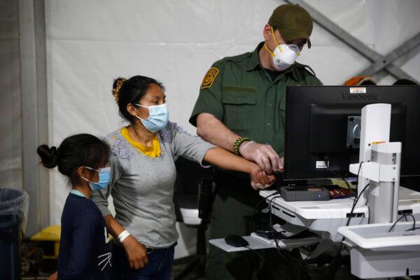 An illegal immigrant and her daughter have their biometric data entered at the intake area of the Donna Department of Homeland Security holding facility, the main detention center for unaccompanied children in the Rio Grande Valley, in Donna, Texas, on March 30, 2021. (Dario Lopez-Mills/AP Photo)