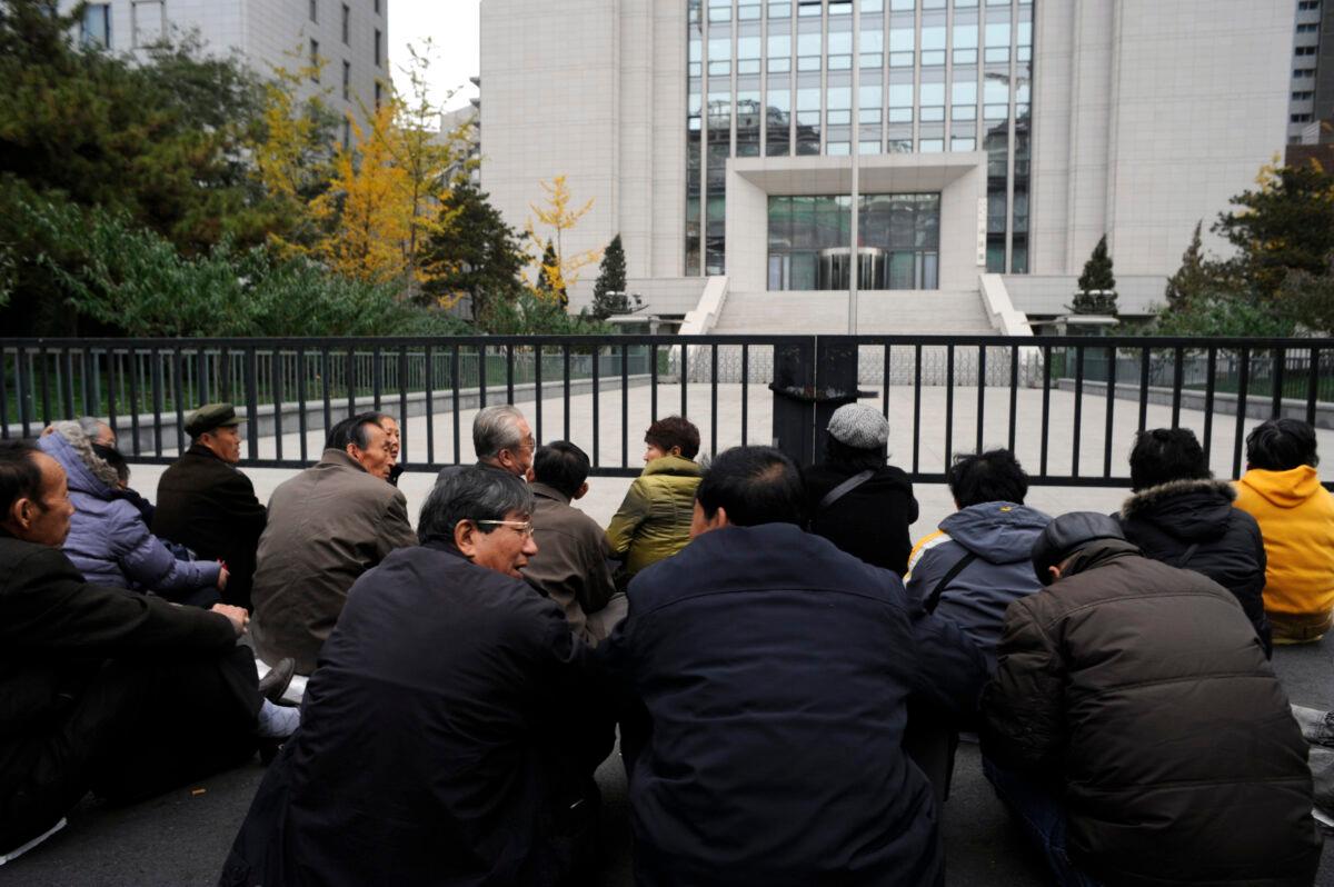 A group of elderly retirees stages a sit-down protest outside the Chinese Ministry of Justice over their unpaid pensions in Beijing on Nov. 8, 2011. (Goh Chai Hin/AFP via Getty Images)