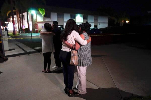 People comfort each other near a business building where a shooting occurred in Orange, Calif., on March 31, 2021. (AP Photo/Jae C. Hong)