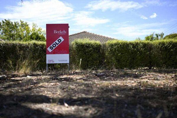 A real estate advertising board is seen next to a house in Canberra, Australia, on March 1, 2019. (AAP Image/Lukas Coch)