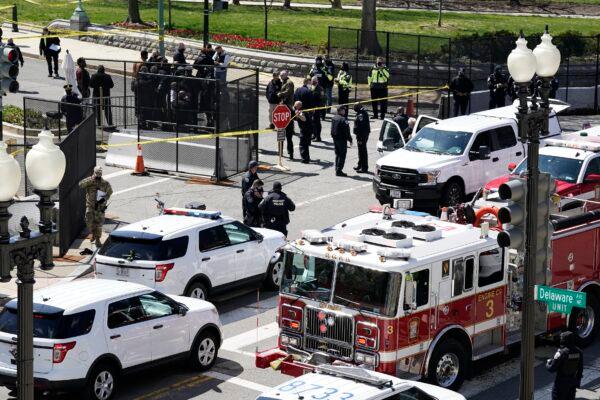 Police and fire officials stand near a car that crashed into a barrier on Capitol Hill in Washington, on April 2, 2021. (J. Scott Applewhite/AP Photo)