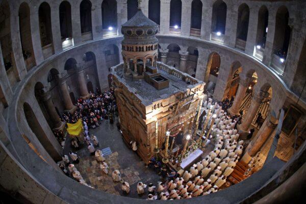 Christian worshippers, monks, and friars walk in procession around the Edicule, traditionally believed to be the burial site of Jesus Christ, during a mass to commemorate the Washing of the Feet on Holy Thursday, at the Church of the Holy Sepulchre in Jerusalem, on April 1, 2021. (Emmanuel Dunand/AFP via Getty Images)