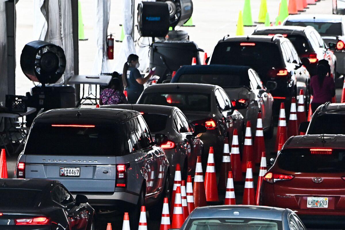 Cars line up as people wait to receive a COVID-19 vaccine at a drive-thru site at Hard Rock Stadium in Miami, Fla., on April 1, 2021. (Chandan Khanna/AFP via Getty Images)