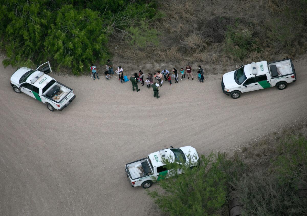 U.S. Border Patrol agents take illegal immigrants into custody, as seen from a Texas Department of Public Safety helicopter, near the U.S.–Mexico Border in McAllen, Texas, on March 23, 2021. (John Moore/Getty Images)