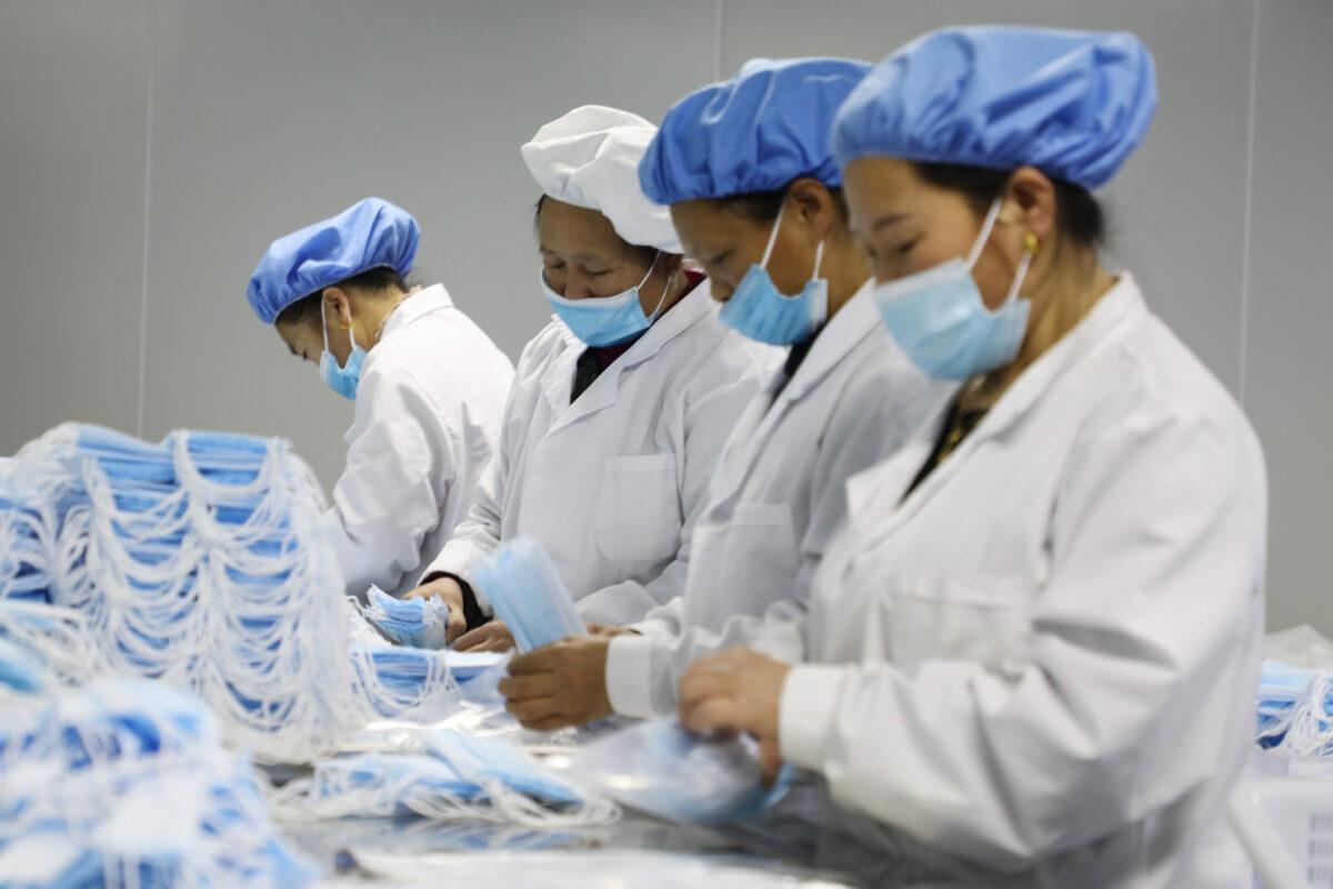 Workers making medical masks at a factory in Jishou, Hunan Province, China, on Jan. 28, 2021. (STR/AFP via Getty Images)