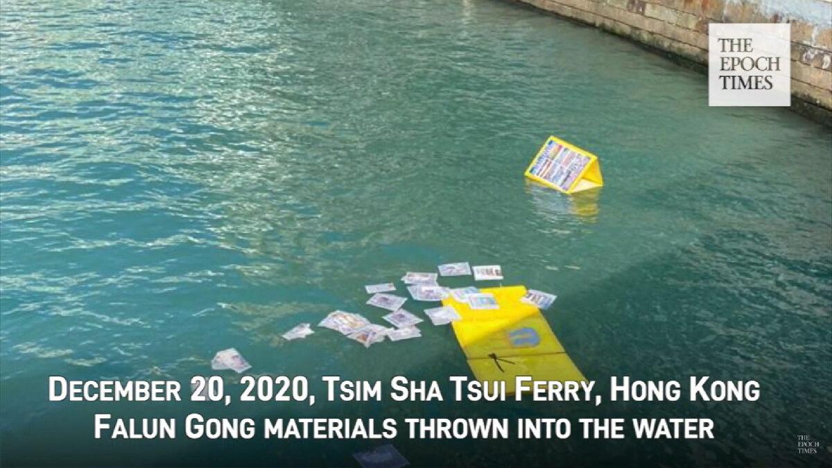 Printouts and display boards from a Falun Gong booth in Tsim Sha Tsui are thrown into a nearby harbor on Dec. 20, 2020. (Screenshot via YouTube)