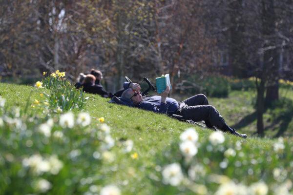 People enjoy the sunny weather in Sefton Park in Liverpool, England, on April 4, 2021. (Peter Byrne/PA via AP)