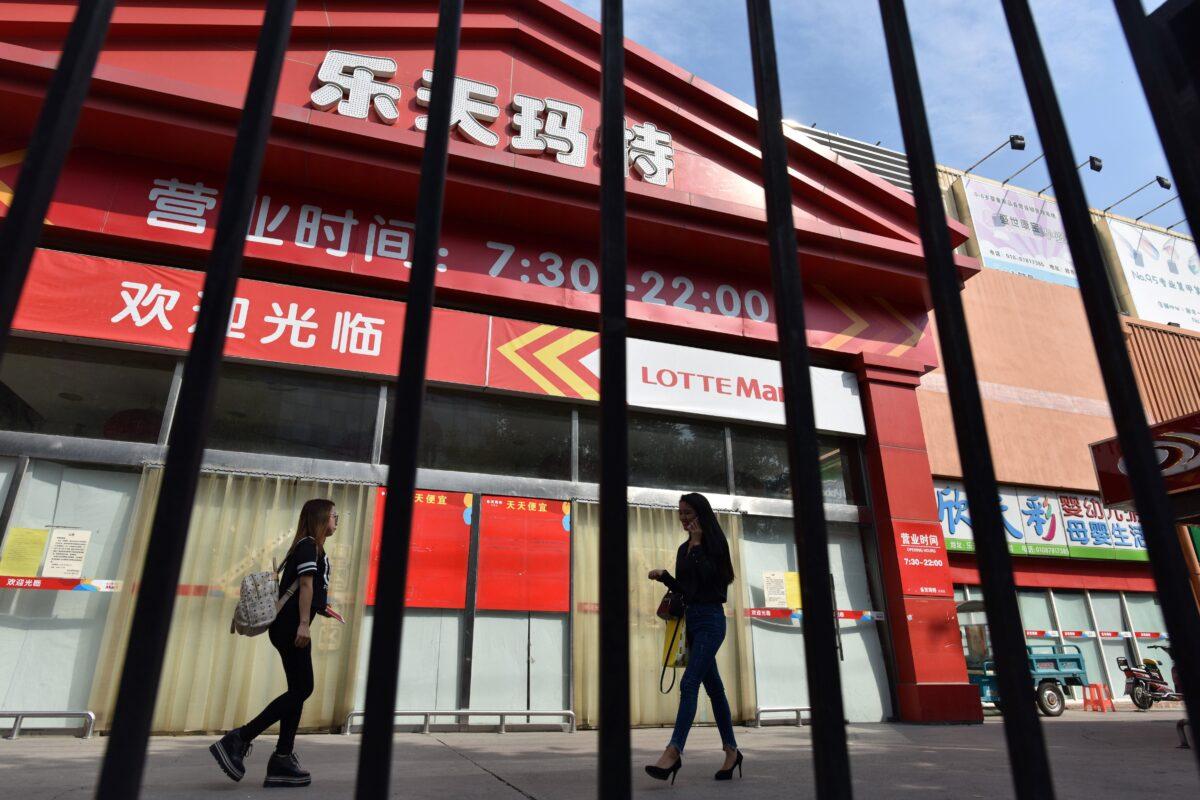 People walk past a closed Lotte Mart store in Beijing on Sept. 15, 2017. The South Korean conglomerate has recently completely withdrawn from the Chinese market. (Greg Baker/AFP/Getty Images)