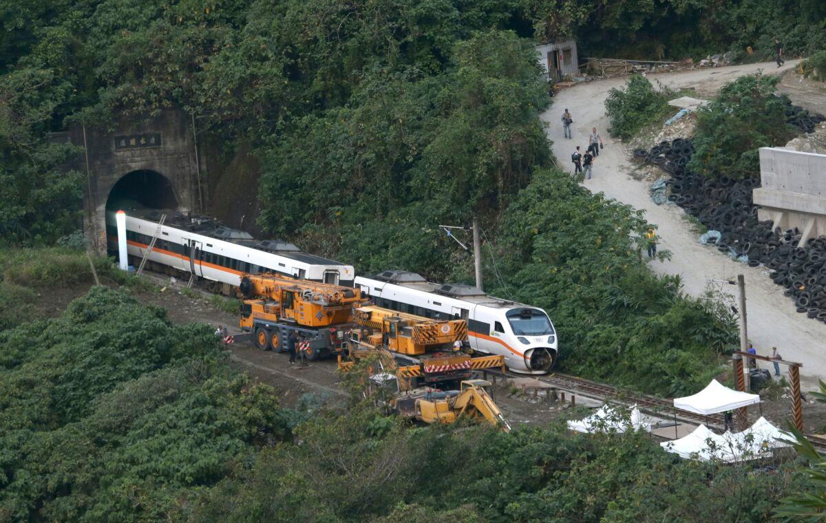 Rescue workers remove a part of the derailed train near Taroko Gorge in Hualien, Taiwan, on April 3, 2021. (Chiang Ying-ying/AP Photo)