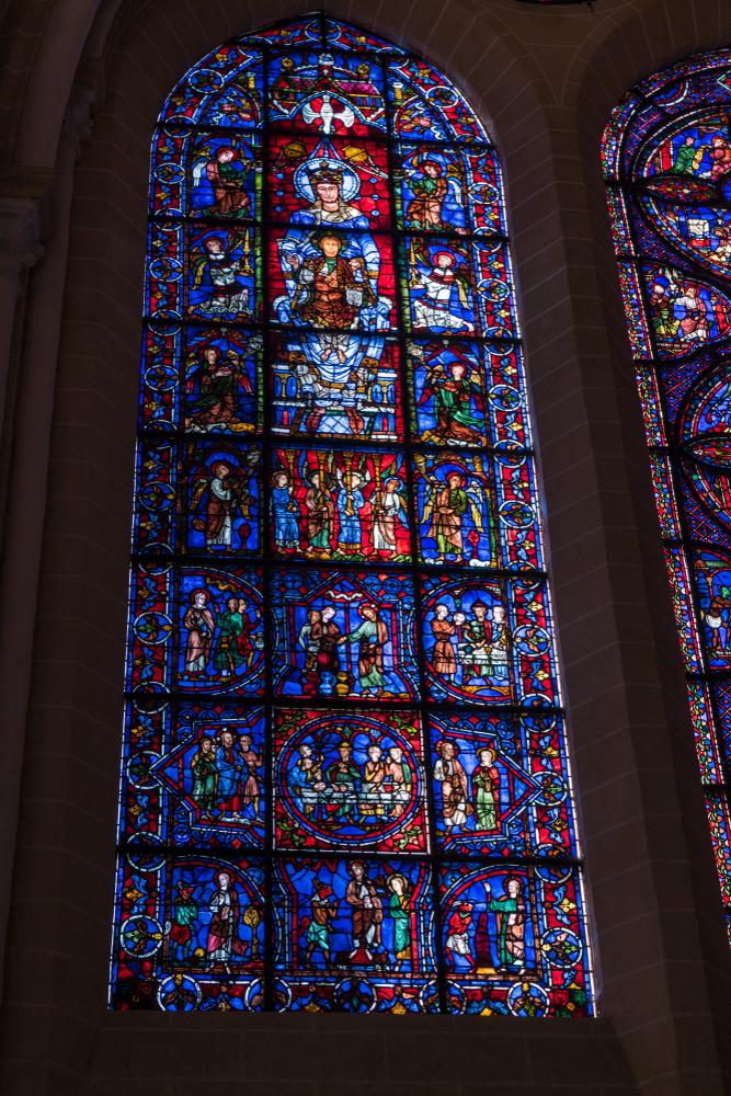 One of the oldest stained glass windows in the cathedral is the "Notre-Dame de la Belle-Verrière," or "The Blue Virgin" window. The upper window dates from around 1180 and shows the Virgin Mary sitting on a throne as she holds Christ on her lap. His hand gesture signifies a blessing. (Cynthia Liang/Shutterstock)