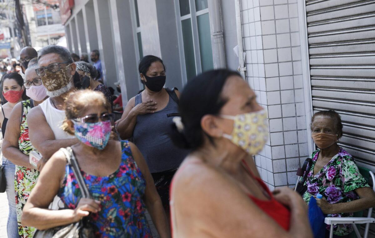 People wait in line to receive a dose of the Sinovac's CoronaVac vaccine during a vaccination day for 65-year-old and older citizens in Duque de Caxias near Rio de Janeiro, Brazil on March 29, 2021. (Ricardo Moraes/Reuters)