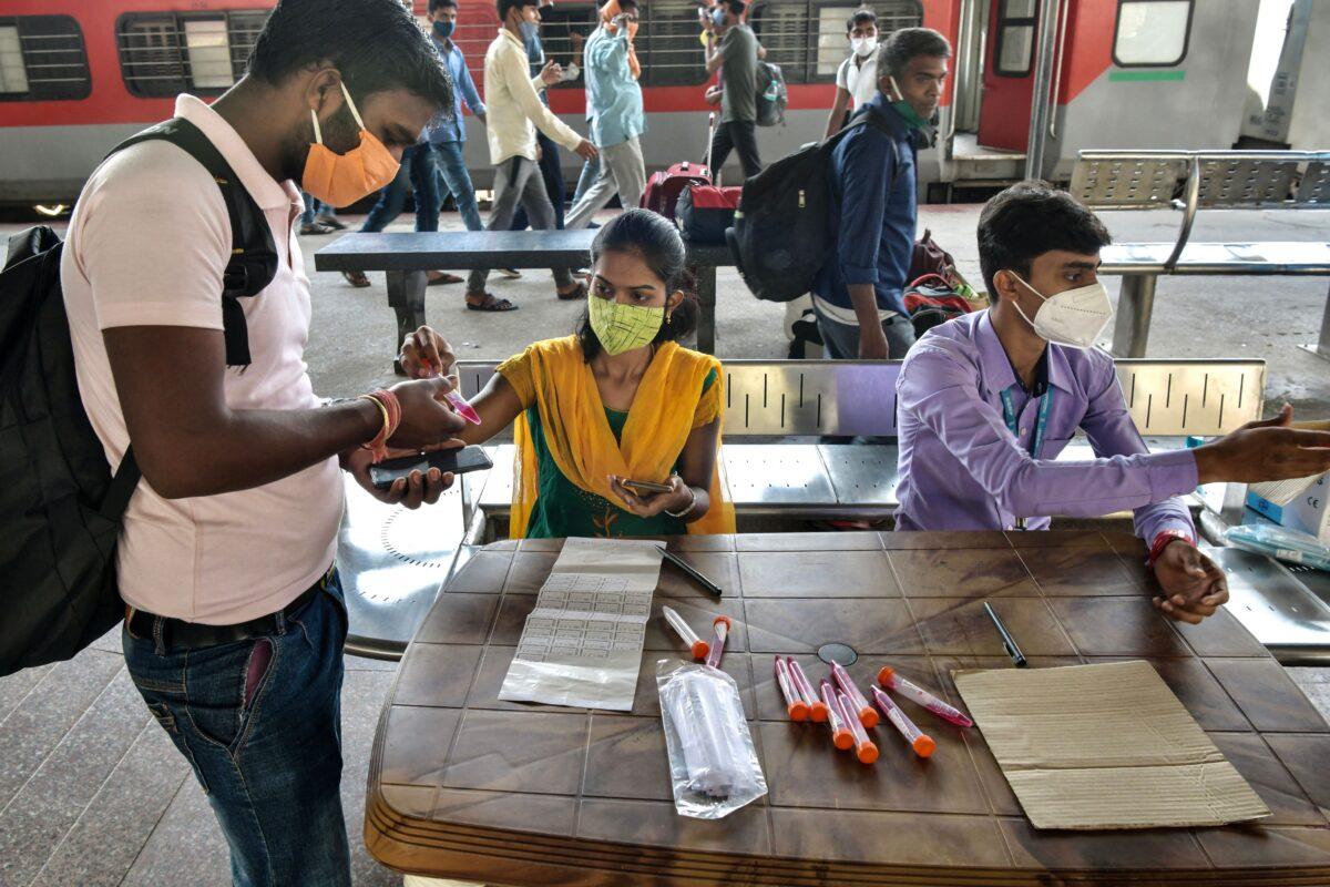 Health workers register passengers to collect samples for virus tests at the Yesvantpur railway station in Bangalore, India, on April 5, 2021. (Manjunath Kiran/AFP via Getty Images)