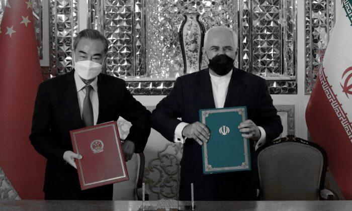 Chinese Foreign Minister Wang Yi and his Iranian counterpart, Mohammad Javad Zarif (R), pose for a picture after signing an agreement in Tehran, Iran, on March 27, 2021. (AFP via Getty Images)
