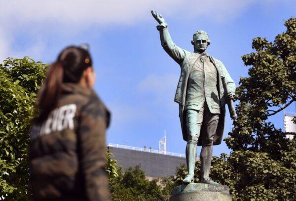 People walk past a statue of Captain James Cook stands in Sydney's Hyde Park on August 25, 2017 (William West/AFP via Getty Images)