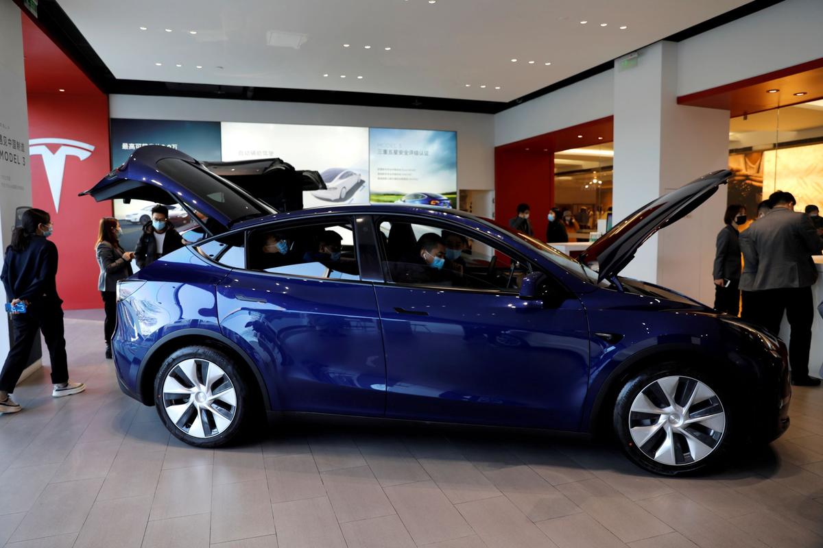 Visitors check a China-made Tesla Model Y sport utility vehicle (SUV) at the electric vehicle maker's showroom in Beijing, China, on Jan.5, 2021. (Tingshu Wang/Reuters)