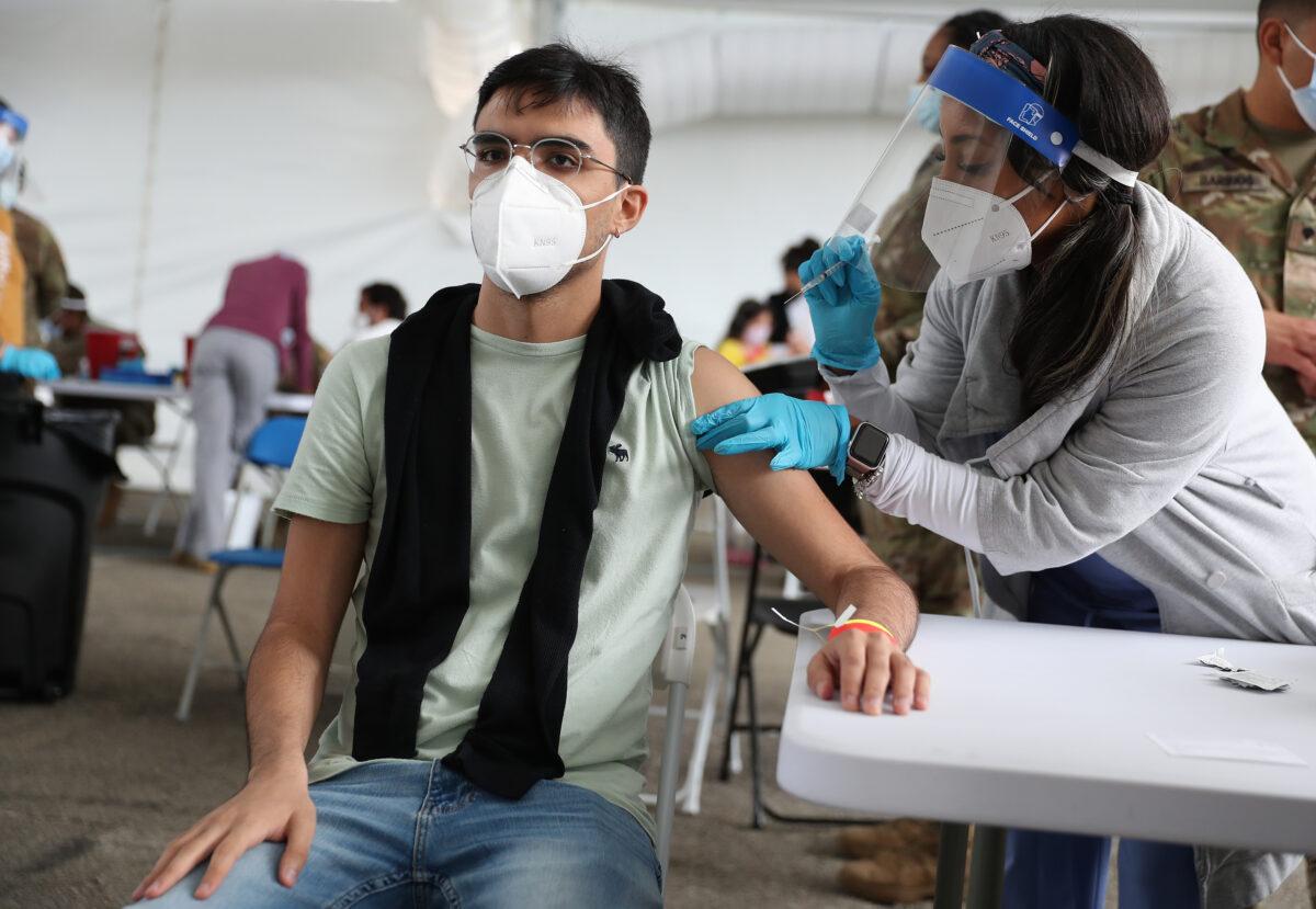 A health care worker immunizes Juan Guevara with the Pfizer COVID-19 vaccine at the Miami Dade College North Campus in North Miami, Fla., on March 10, 2021. (Joe Raedle/Getty Images)