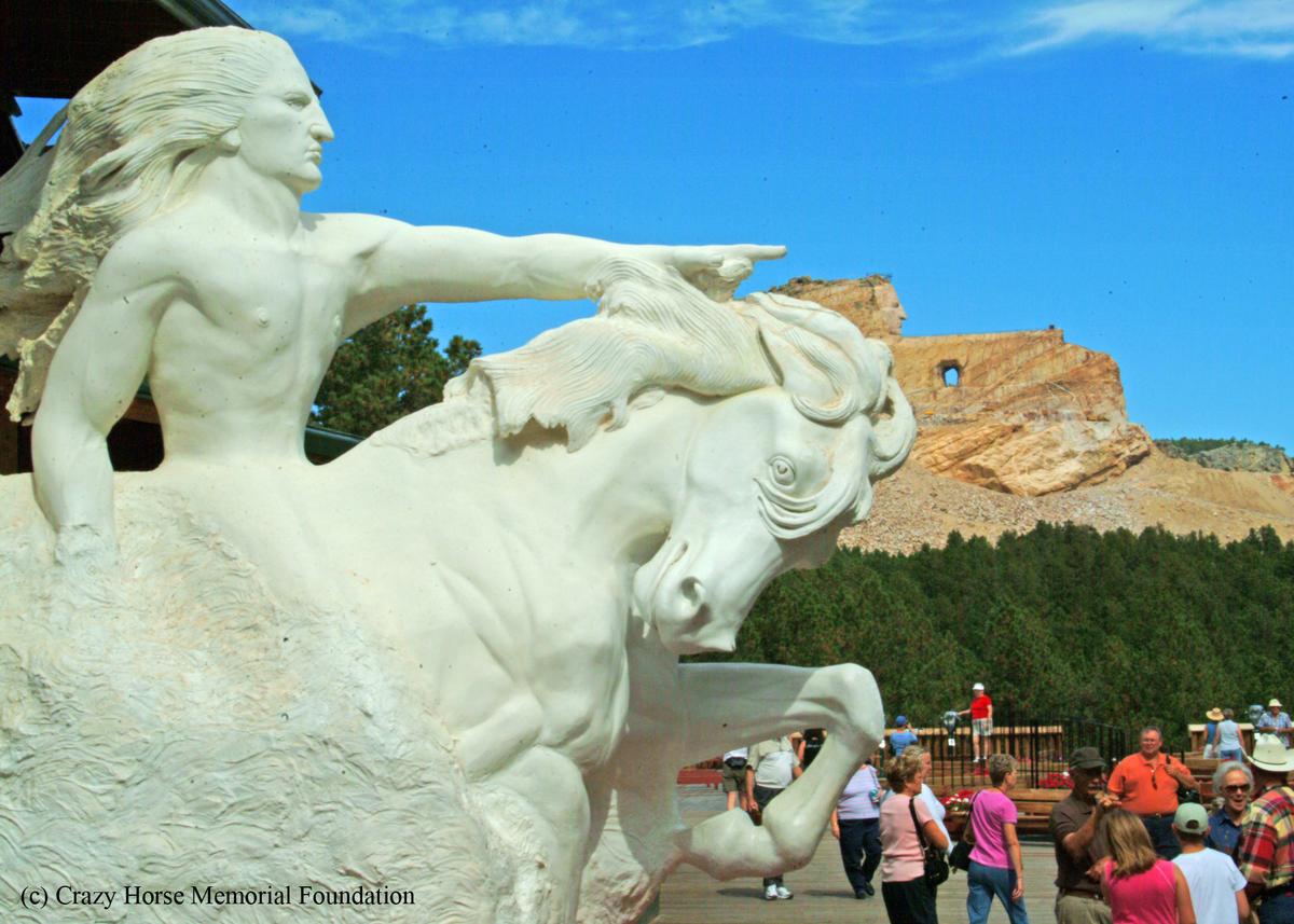 A 16-ton plaster model created by sculptor Korczak Ziolkowski stands on a viewing veranda, enabling visitors to better visualize what his Crazy Horse Memorial (seen in the background a mile away) will look like when finished. (Fred J. Eckert)