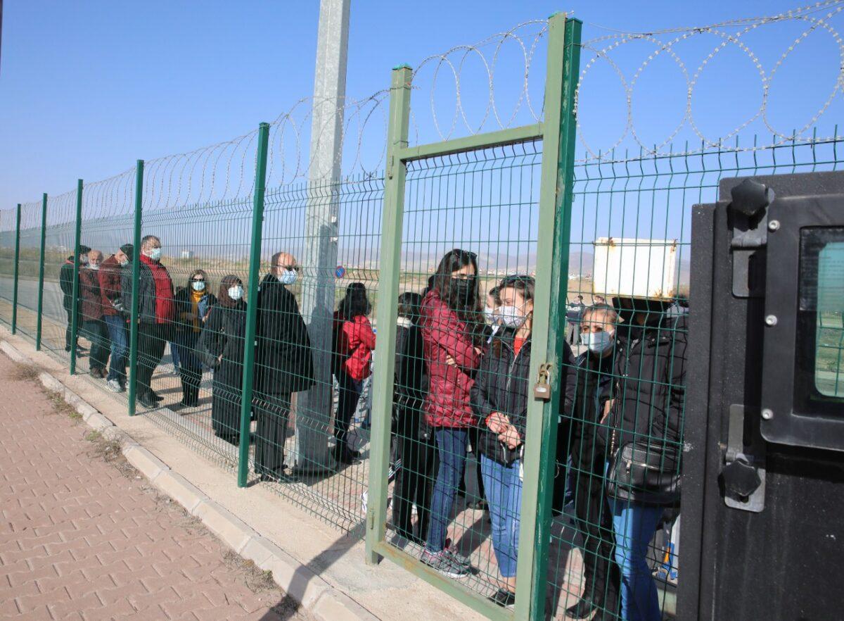 People wait outside a courthouse prior to the start of the trial of 497 defendants, in Sincan, outside the capital Ankara, Turkey, on April 7, 2021. (Burhan Ozbilici/AP Photo)