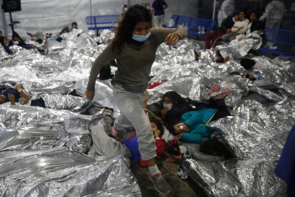 A minor walks over others inside a holding facility run by Customs and Border Patrol in Donna, Texas, on March 30, 2021. (Dario Lopez-Mills/Pool/Getty Images)