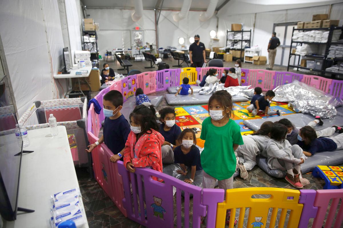 Young unaccompanied migrants, from ages 3 to 9, watch television inside a playpen at the U.S. Customs and Border Protection facility, the main detention center for unaccompanied children in the Rio Grande Valley, in Donna, Texas, on March 30, 2021. (Dario Lopez-Mills/AP Photo)