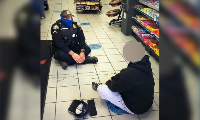 Photo Shows Kind Police Officer Sitting on Floor With Man in Mental Health Crisis in Gas Station