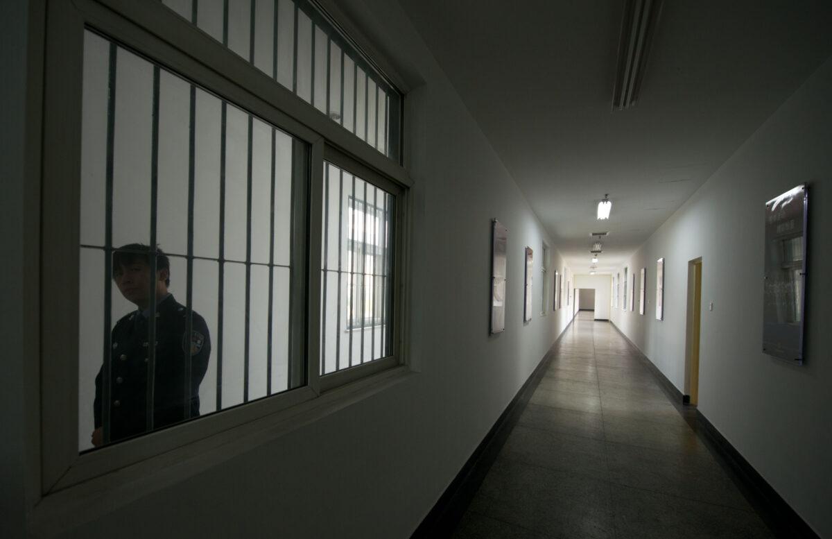 A guard looks through the window of a hallway inside the No.1 Detention Center during a government-guided tour in Beijing on Oct. 25, 2012. (Ed Jones/AFP via Getty Images)
