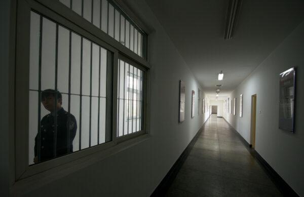 A guard looks through the window of a hallway inside the No.1 Detention Center during a regime-guided tour in Beijing on Oct. 25, 2012. (Ed Jones/AFP via Getty Images)