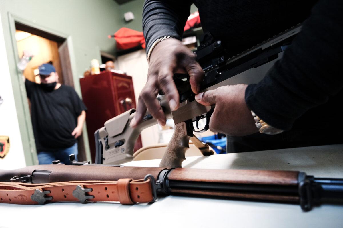 Lateif Dickerson handles some of his rifles at his gun instruction headquarters in Jersey City, N.J., on March 25, 2021. (Spencer Platt/Getty Images)