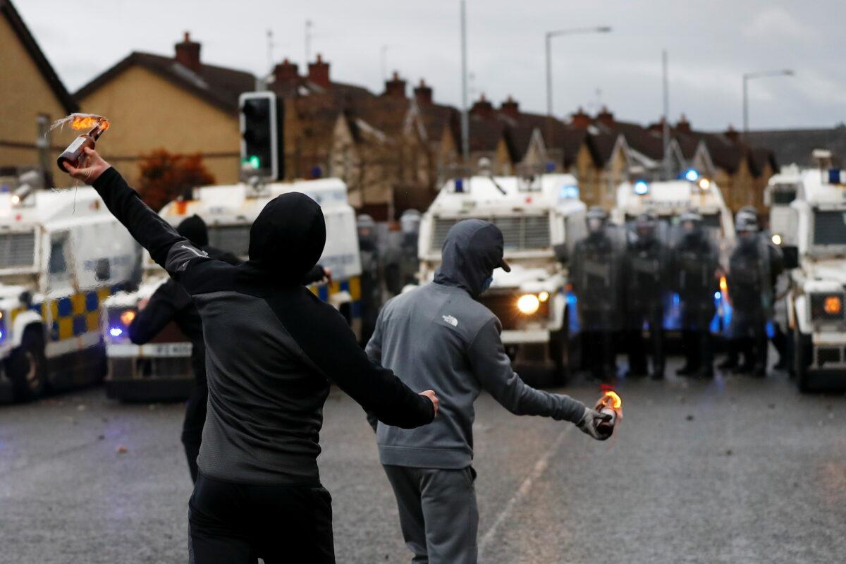 Rioters throw burning bottles at the police on the Springfield Road as protests continue in Belfast, Northern Ireland, on April 8, 2021. (Jason Cairnduff/Reuters)