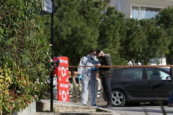 Forensic experts are seen on the road where Greek journalist George Karaivaz was fatally shot in the Alimos suburb of Athens, Greece, on April 9, 2021. (Costas Baltas/Reuters)