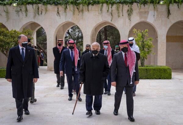 Jordan’s King Abdullah II, second right, Prince Hamzah bin Al Hussein, fourth right in blue mask, Prince Hassan bin Talal, fifth right, and others arriving to visit the tombs of former kings, in Amman, Jordan, on April 11, 2021. (Royal Court Twitter Account via AP)