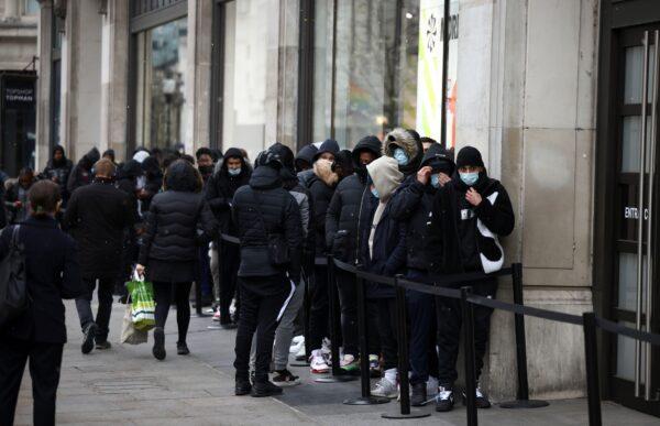 People queue outside a shop, as the COVID-19 restrictions ease, in London, Britain, on April 12, 2021. (Henry Nicholls/Reuters)