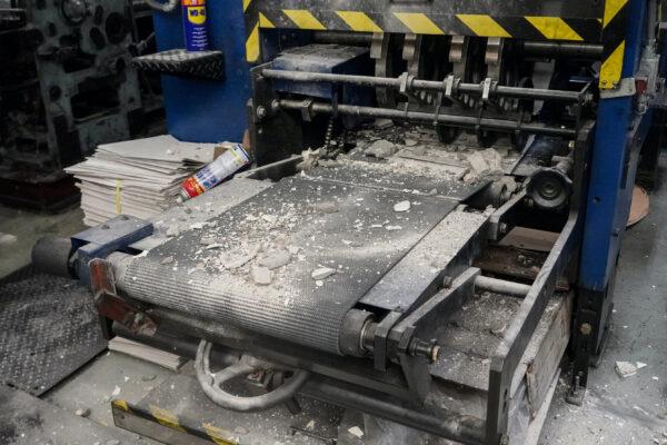 Construction debris on top of printing press equipment at the print shop that prints the Hong Kong edition of The Epoch Times on April 12, 2021. (Adrian Yu/The Epoch Times)
