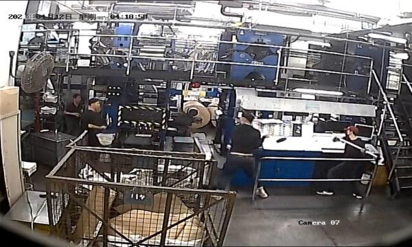 A CCTV screenshot showing intruders dressed in black using sledge-hammers to damage printing press equipment at the print shop of the Hong Kong edition of The Epoch Times on April 12, 2021. (The Epoch Times)