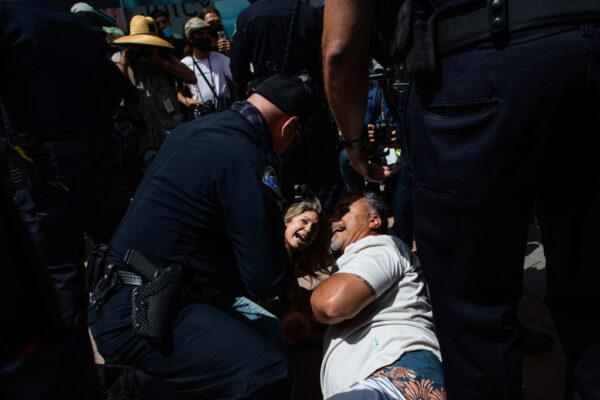 Police officers detain people during a protest against white supremacy in Huntington Beach, Calif., on April 11, 2021. (Apu Gomes/Getty Images)