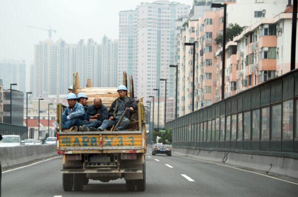 Workers are commuting on the back of a truck on an elevated road in Guangzhou, southern China's Guangdong Province on Jan. 10, 2016. (Johannes Eisele/AFP via Getty Images)