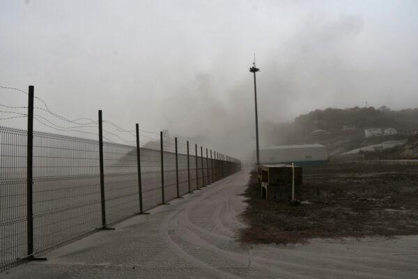 A road is blanketed in volcanic ash at the international airport in Kingstown, on the eastern Caribbean island of St. Vincent, on April 10, 2021. (Orvil Samuel/AP Photo)