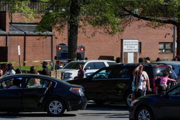 People gather outside Austin East High School in Knoxville, Tenn., as Knoxville police work the scene following a shooting at the school on April 12, 2021. (Wade Payne/AP Photo)