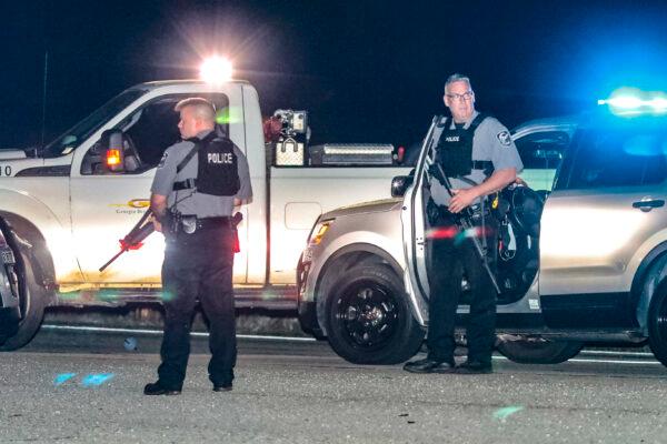Police officers stand at the scene following a police chase in Carroll County, Ga., on April 12, 2021. (John Spink/Atlanta Journal-Constitution via AP)