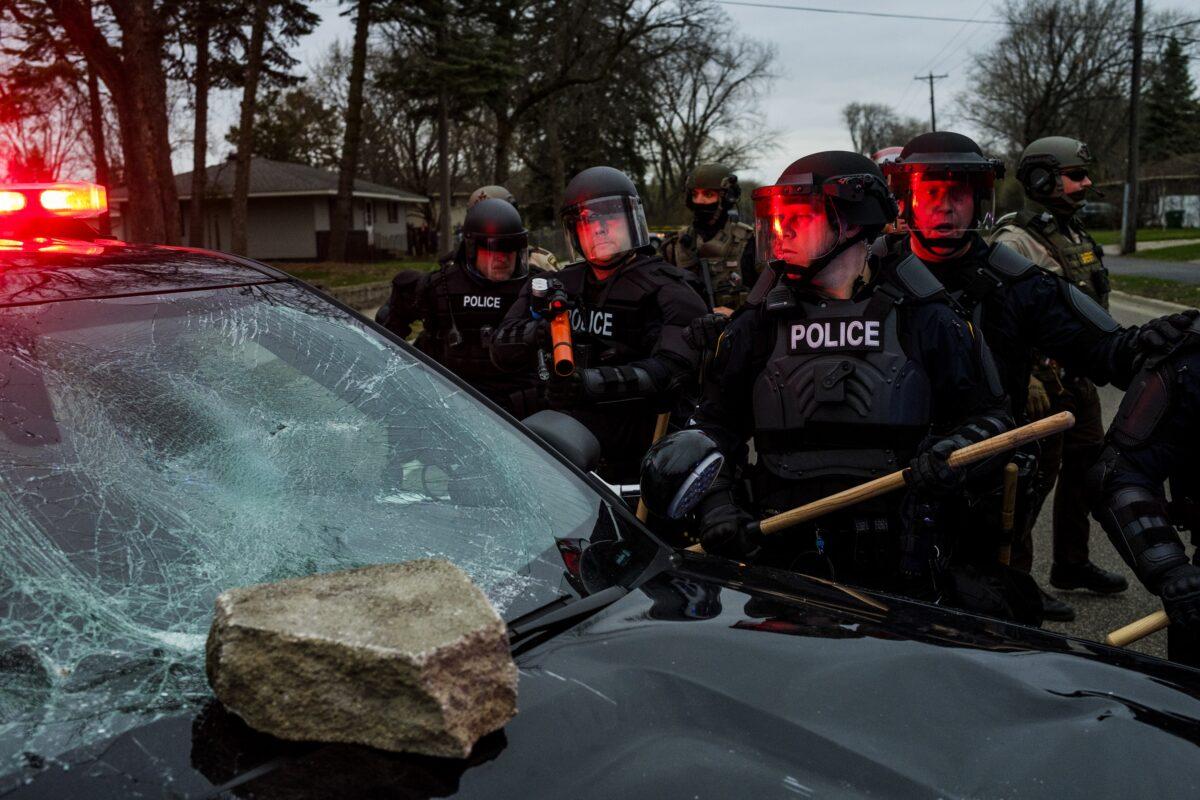 Police surround a cruiser damaged by a rock thrown during a violent demonstration in Brooklyn Center, Minn., on April 11, 2021. (Stephen Maturen/Getty Images)