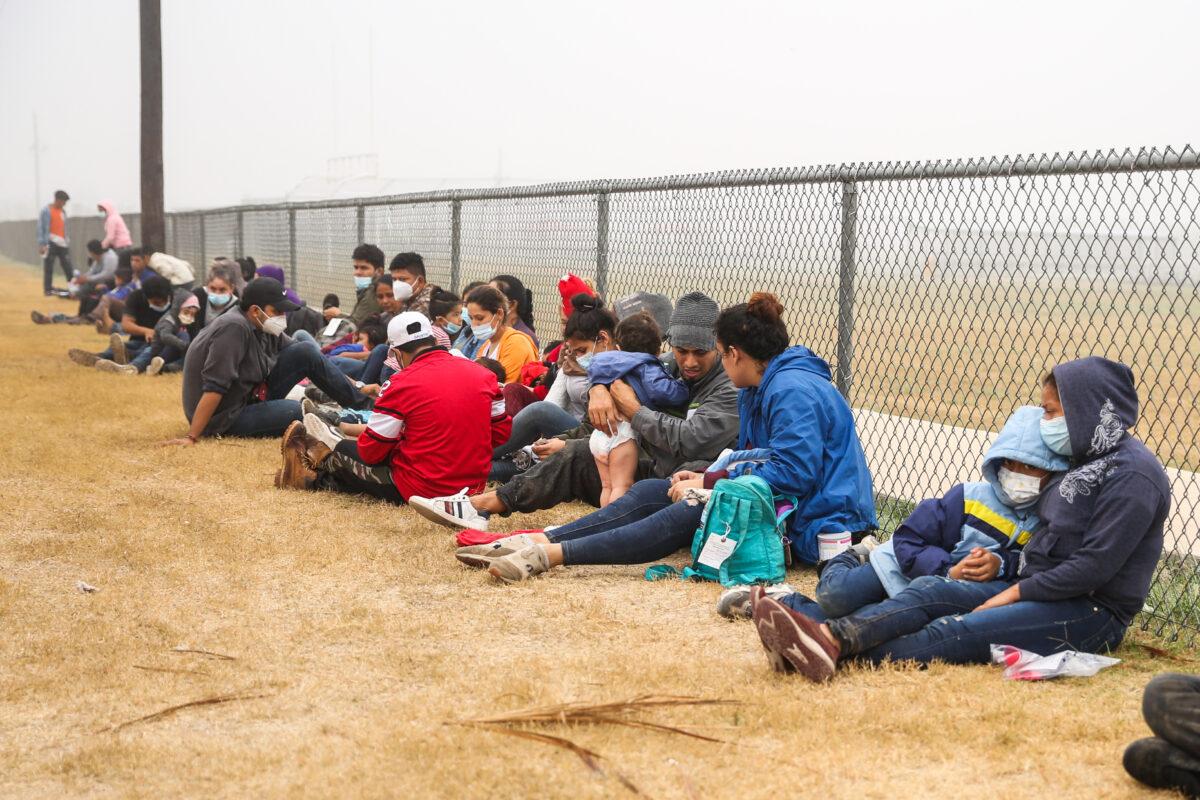 A group of illegal immigrants wait to be processed by Border Patrol after crossing the U.S.-Mexico border in La Joya, Texas, on April 10, 2021. (Charlotte Cuthbertson/The Epoch Times)
