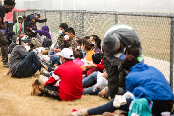 A group of illegal immigrants wait to be processed by Border Patrol after crossing the U.S.–Mexico border in La Joya, Texas, on April 10, 2021. (Charlotte Cuthbertson/The Epoch Times)